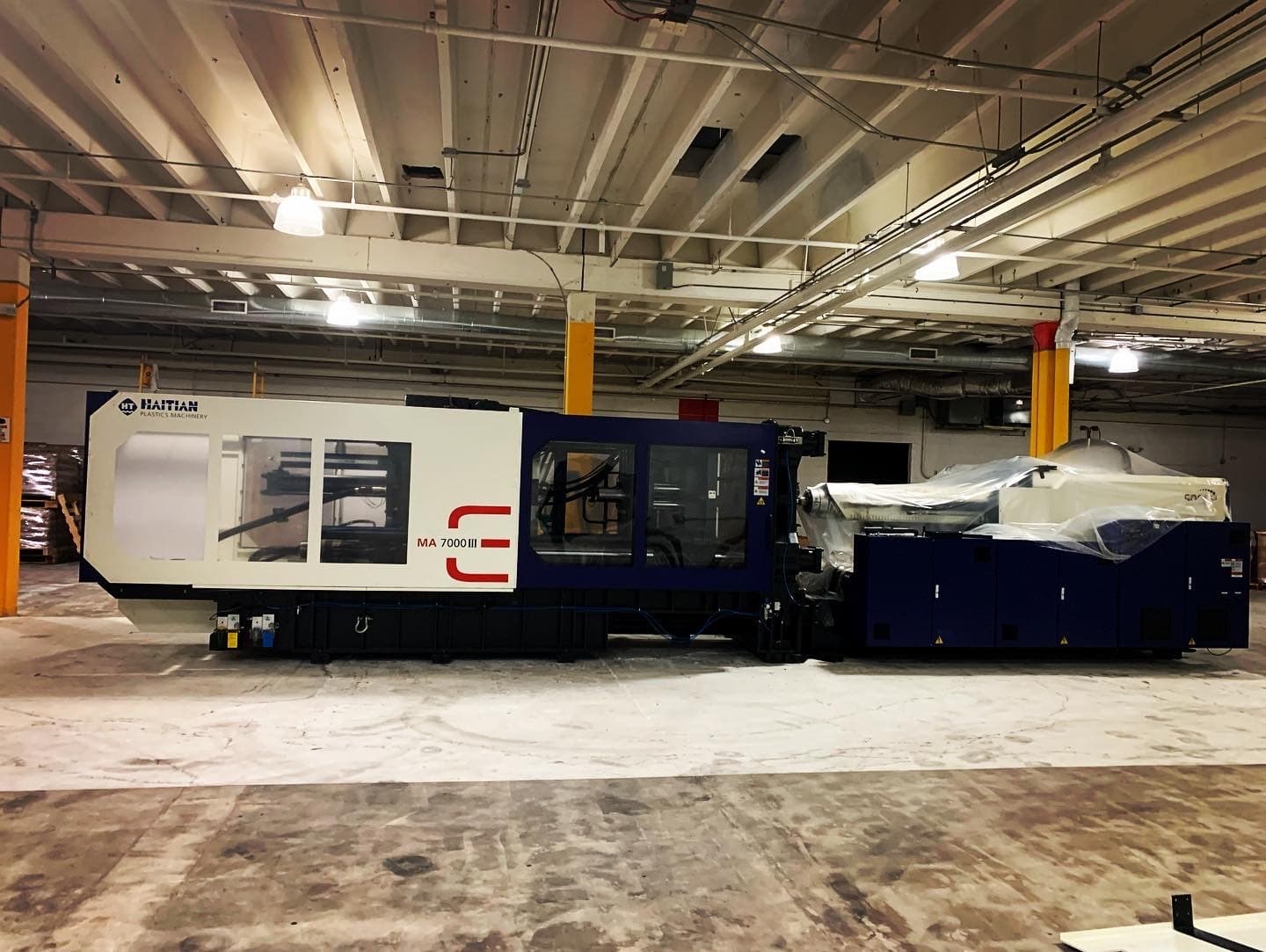 AAA Machinery Riggers crew installing a 75,000 lb injection molding machine in Miami